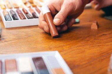 Usta bir çiziği balmumu kalemle kapatır. Laminate ve parke restorasyonu. Ahşap bir yüzey yakın plan onarımı
