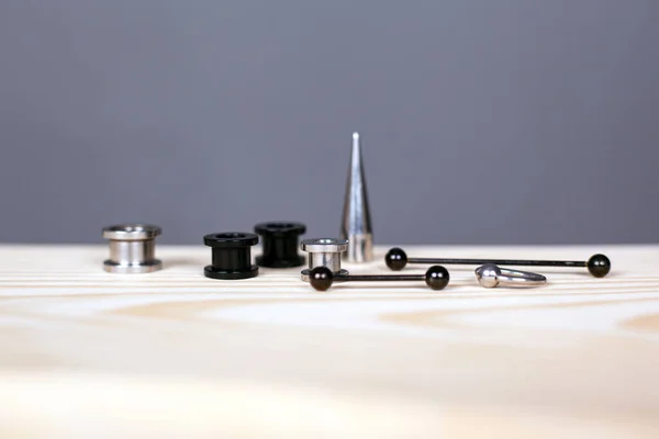 Oorpiercing set. piercing accessoires op grijze achtergrond close-up — Stockfoto