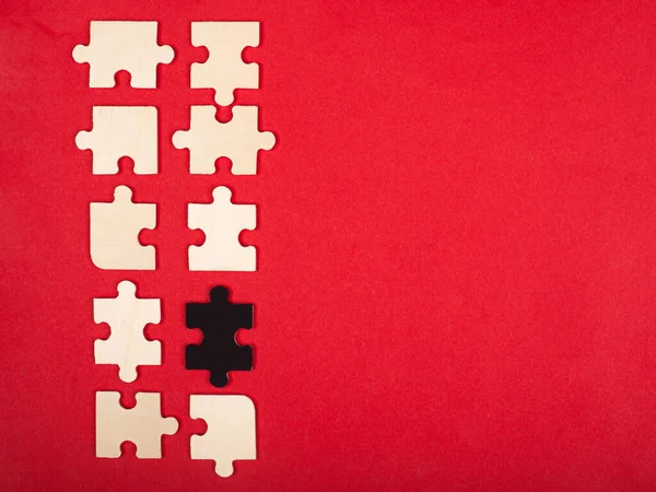 Puzzle in legno bianco e nero su sfondo rosso primo piano vista dall'alto . — Foto Stock