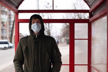 Otobüs durağındaki adam Çin Coronavirus covid-19 virüsünden korkuyor. Wuhan virüs salgını.