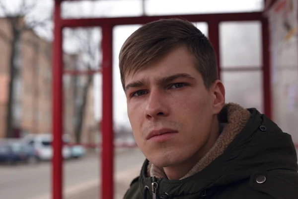 Portret van een jonge man 21-22 jaar oud op een busstation close-up — Stockfoto