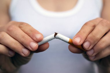 Kadın eli sigarayı yakın plan çekimde kırıyor. Sigarayı bırakmak, kötü alışkanlık, sigara ve nikotin tütününden zarar görmek, bağımlılık