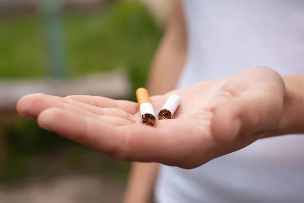 Mano sosteniendo el cigarrillo roto por la mitad de cerca. concepto de salud, dejar de fumar, mal hábito, daño por el consumo de tabaco, adicción —  Fotos de Stock