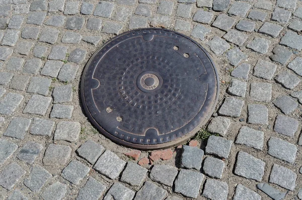 A worn circular iron drain cover — Stock Photo, Image