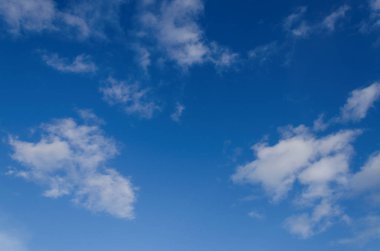 Masmavi bir gökyüzü seyrek beyaz kabarık bulutlar ile