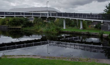 Bir kentsel endüstriyel konumda bir nehir üzerinde modern çelik yaya köprüsü