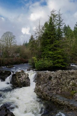 Ağaçlar küçük bir ada ve, köy Betws Y Coed North Wales ön planda bir şelale ile güzel nehir sahne