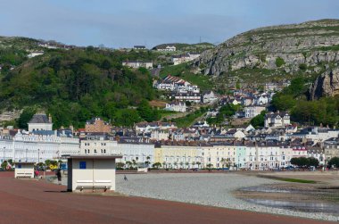 Llandudno, İngiltere: 6 Mayıs 2019: Kuzey Sahili, Llandudno 'daki gezinti alanının genel manzarası. Çok az insan sabah güneşinin tadını çıkarmak için dışarıda..