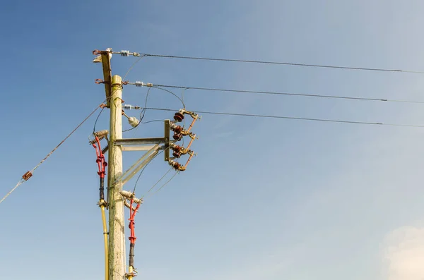 Bir ahşap elektrik dağıtım pilonu. Dağıtım kablolarının üstten ve yeraltından geçmesini kolaylaştırıyor..
