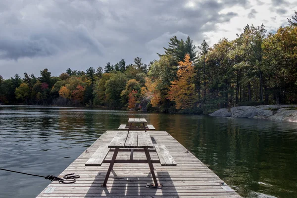 Mesas de piquenique na doca no lago — Fotografia de Stock