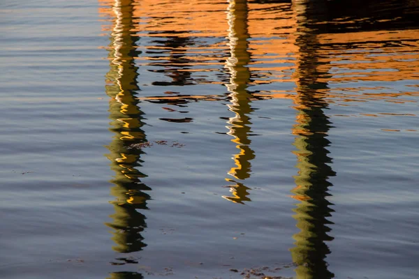 Pfosten auf der Seebrücke spiegeln sich im Wasser — Stockfoto
