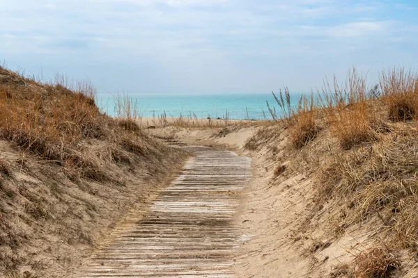 Sauble Beach, Ontario, Kanada 'da kum tepelerinden Huron Gölü' ne bir bahar günü sahil erişim yolu.