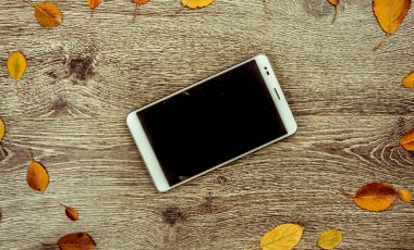 Beyaz modern tablet pc ile sonbahar yaprakları ile rustik klasik ahşap arka plan boş boş ekran.