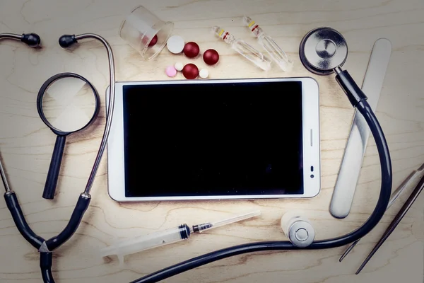 Tablet PC con objetos médicos en un escritorio — Foto de Stock