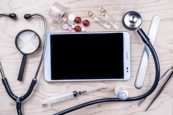 Tablette PC avec objets médicaux sur un bureau — Photo