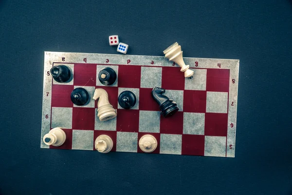 Various board games and figurines over checkers board — Stock Photo, Image