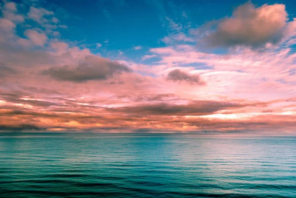 Vista surreal multicolorida do pôr do sol de uma costa rochosa . — Fotografia de Stock