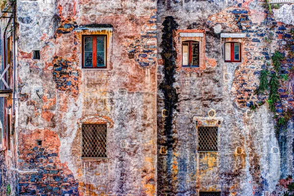 Rode vintage oude bakstenen muur met ramen en groene klimop — Stockfoto
