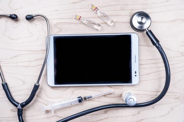 Tablet pc met medische objecten op een bureau — Stockfoto