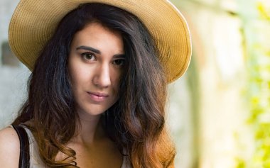 Sokakta yaz gününde şapkalı kız.