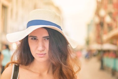 Sokakta yaz gününde şapkalı kız.