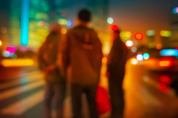 Abstrakter Hintergrund von Menschen, die nachts über den Fußgängerüberweg in Shanghai, China gehen. lizenzfreie Stockfotos