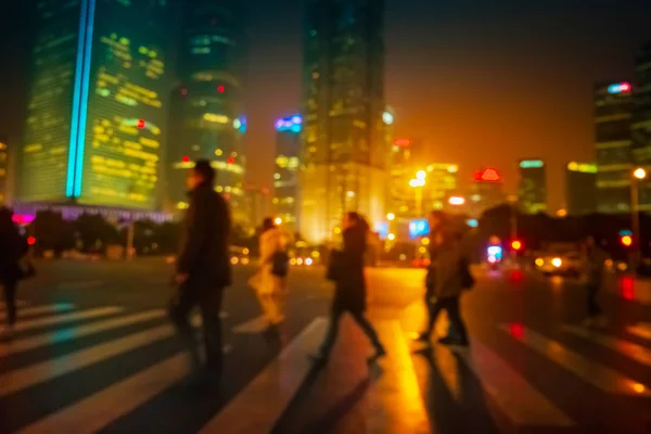 Abstracte achtergrond van mensen over de oversteekplaats bij nacht in Shanghai, China. Stockfoto