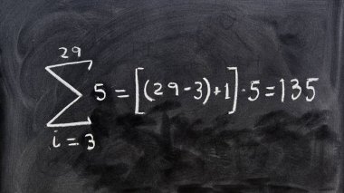 Tahtaya tebeşirle elle yazılmış matematik işlemi