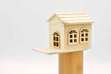 Beyaz arka planı olan küçük tahta bir ev.