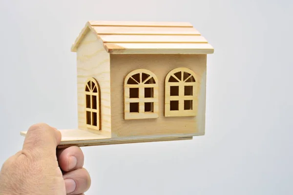 白地に小さな木造の家を持つ手 — ストック写真