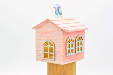Tahta minyatür ev, domuz kumbarası, 20 Euro 'luk banknot.