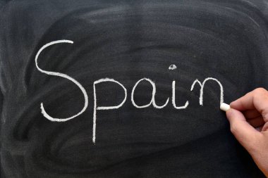 Tahtaya tebeşirle İspanya kelimesini yazan el yazısı.