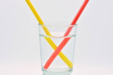 Sarı ve kırmızı kalemler, bir bardak suyun içinde, ışık kırılması açıklaması