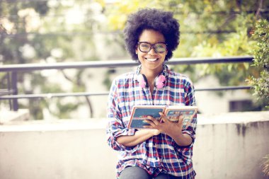 Kitap ile gülümseyen genç afro kadın 