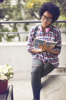 Kitap ile gülümseyen genç afro kadın 