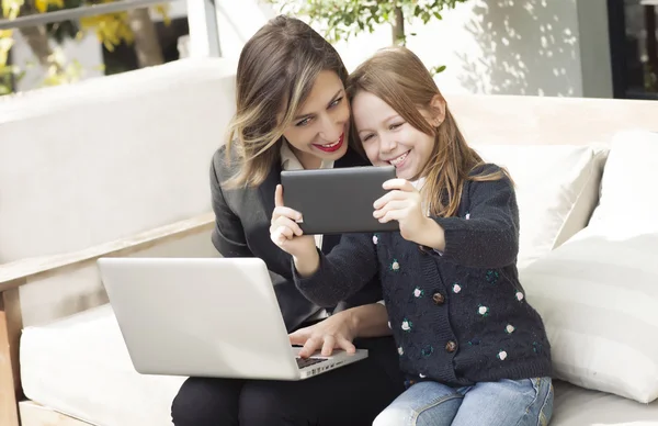 Щаслива мати і дочка з ноутбуком і планшетом — стокове фото