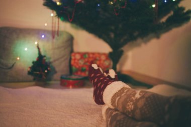 Noel ağacının önünde Istirahat bacaklar