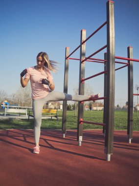 Genç Atletik Kadın Parktaki Duvar Parmaklıklarında Bacakları Esnetiyor