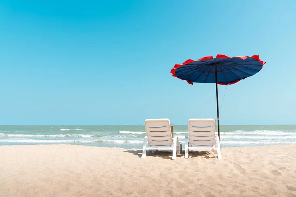 Bela praia. Cadeiras e guarda-chuva na praia tropical arenosa Imagens De Bancos De Imagens Sem Royalties