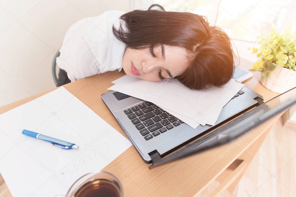 Young tired woman at office desk sleeping with eyes closed sleep deprivation and stressful life concept. Hard work.