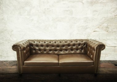 Koyu kahverengi vintage güzel lüks vintage kanepe iç gri beton doku duvar odadaki ile. Moda kavramı, gevşeme kavramı metin reklam için boş alan ile. Vintage retro arka plan.