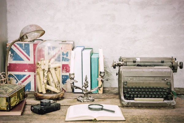 Closeup of workplace with open book stationery items and retro lamp on wooden table with white concrete background.Vintage filtered. Education concept. Reading and researching concept.