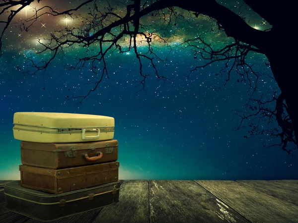 堆积的皮革行李在木木板与星星在夜空背景 旅游理念 梦幻景观 — 图库照片