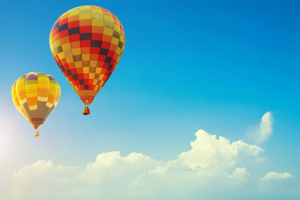 Dos globos de aire caliente de colores en el hermoso cielo azul con — Foto de Stock