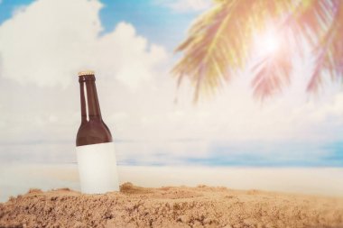 Kum plaj arka plan ile boş Logo bira şişesi