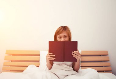 Yatağa bir kitap okuma sonra uyuyan güzel genç kadın