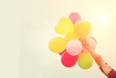 Holding balon gökyüzüne karşı eller genç kadın