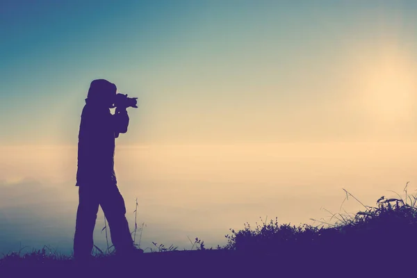 Silhouette einer Fotografin, die im Fokus steht, um ein Foto zu machen — Stockfoto