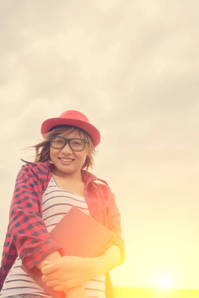 Donna che tiene un libro nei prati al sole del mattino . — Foto Stock