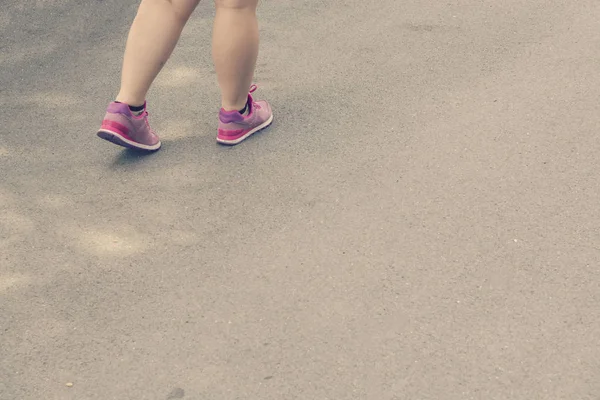 Mulheres gordas pernas andando em sapatos esportivos — Fotografia de Stock